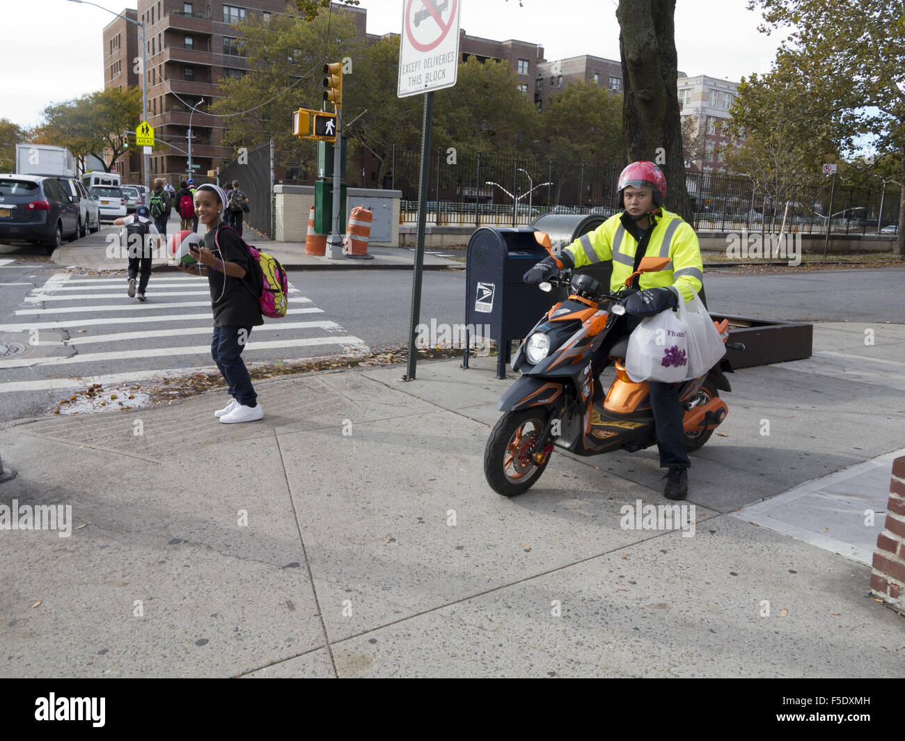 Scène de rue à Kensington, Brooklyn, NY, 2015. Accueil des enfants après l'école. L'homme asiatique fournit la nourriture. Banque D'Images