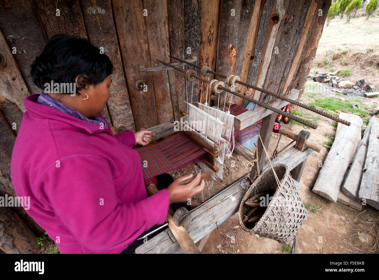 Femme tissant une longueur de tissu Kira sur son métier à tisser en bois fait main intérieure, à partir de la main et teint la laine, Ura, l'Est du Bhoutan Banque D'Images