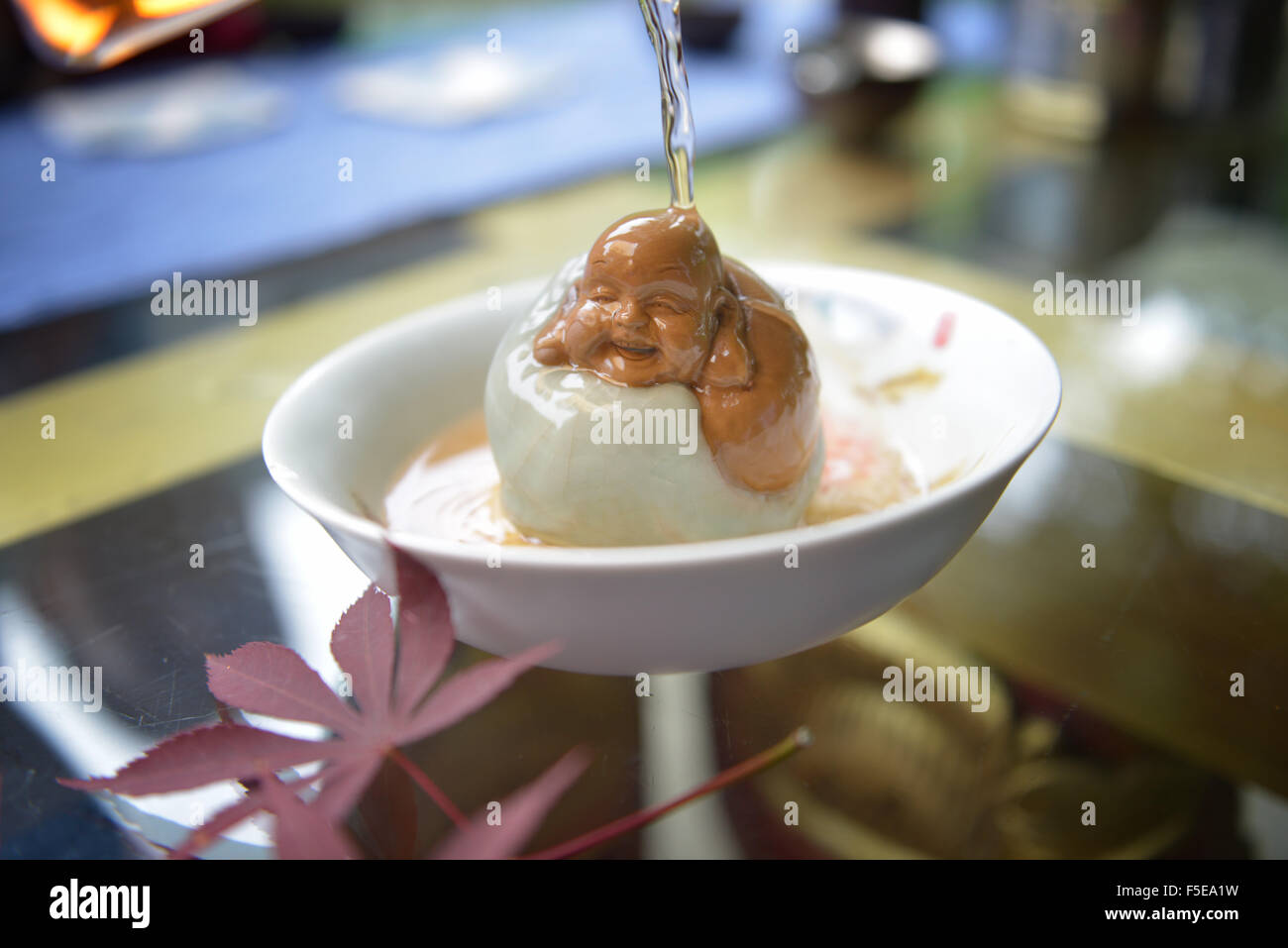 Arrosant un Buddha figurine avec plateau pour la bonne chance, Hangzhou, Zhejiang, China, Asia Banque D'Images