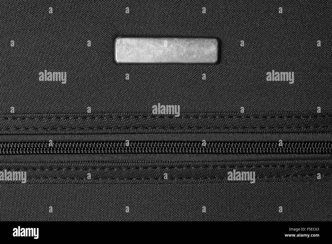 Fermeture éclair et étiquette métallique sur noir Banque D'Images