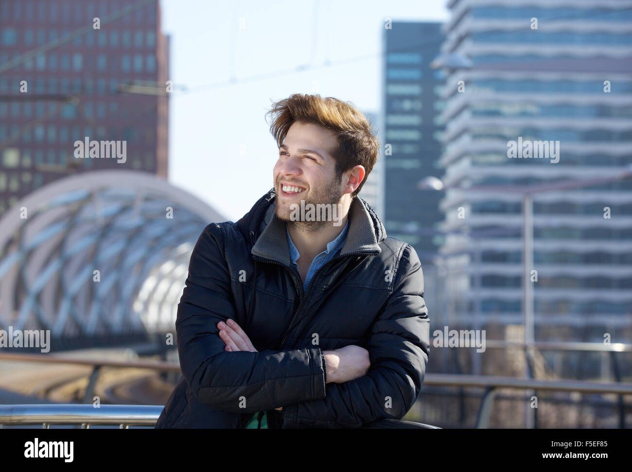 Close up portrait of a young man smiling avec veste d'hiver dans la ville Banque D'Images