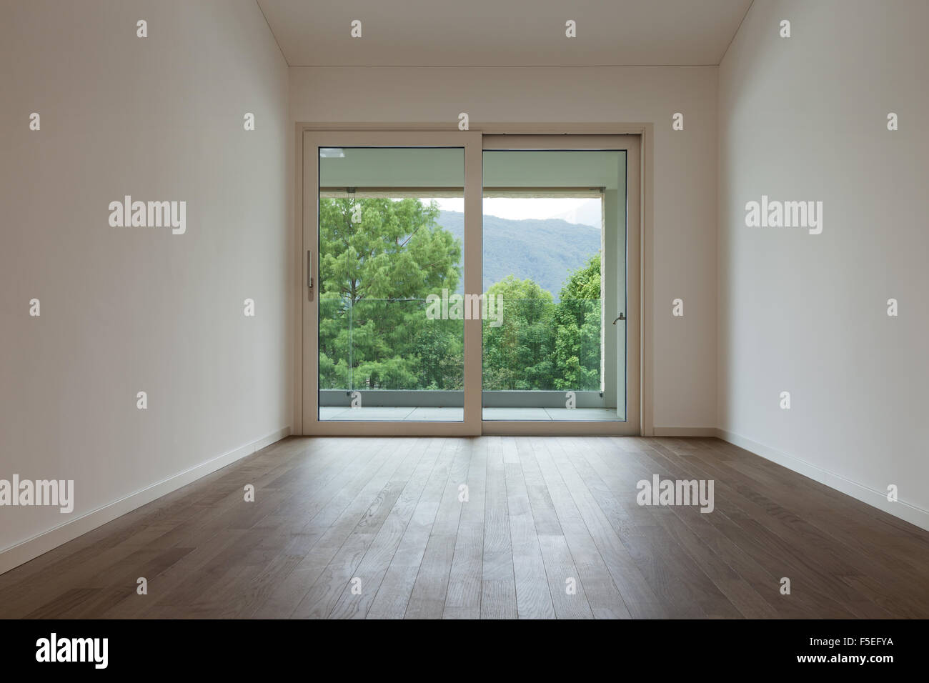 Intérieur de l'appartement neuf, grande chambre avec fenêtre, sol en parquet Banque D'Images