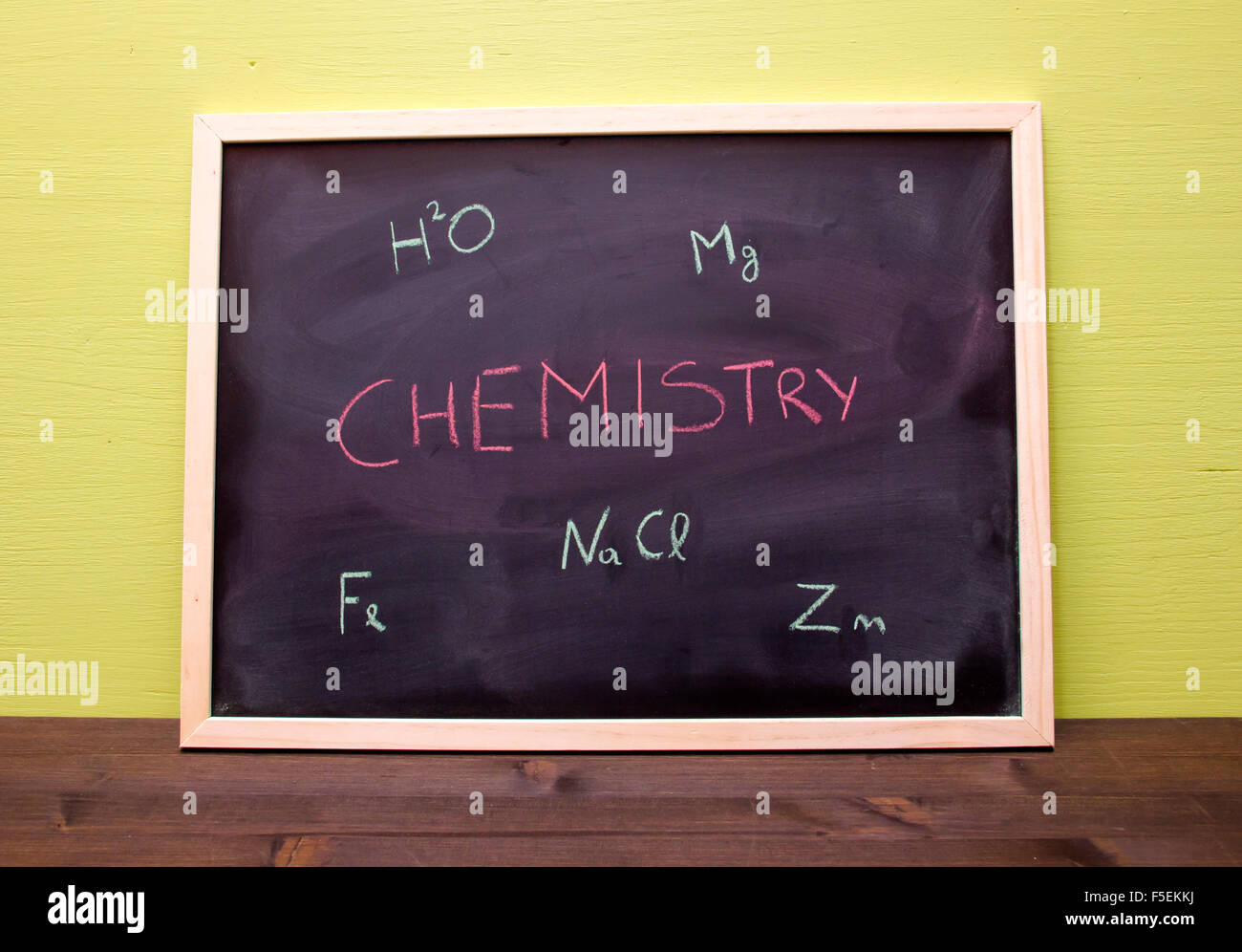 Tableau noir avec leçon de chimie sur mur vert Banque D'Images