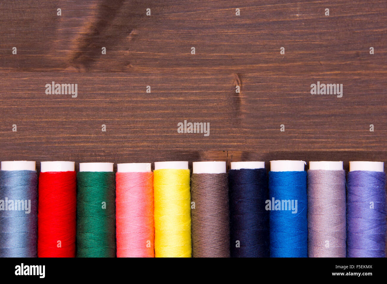 Rangée de fil à coudre de différentes couleurs sur la table en bois Banque D'Images