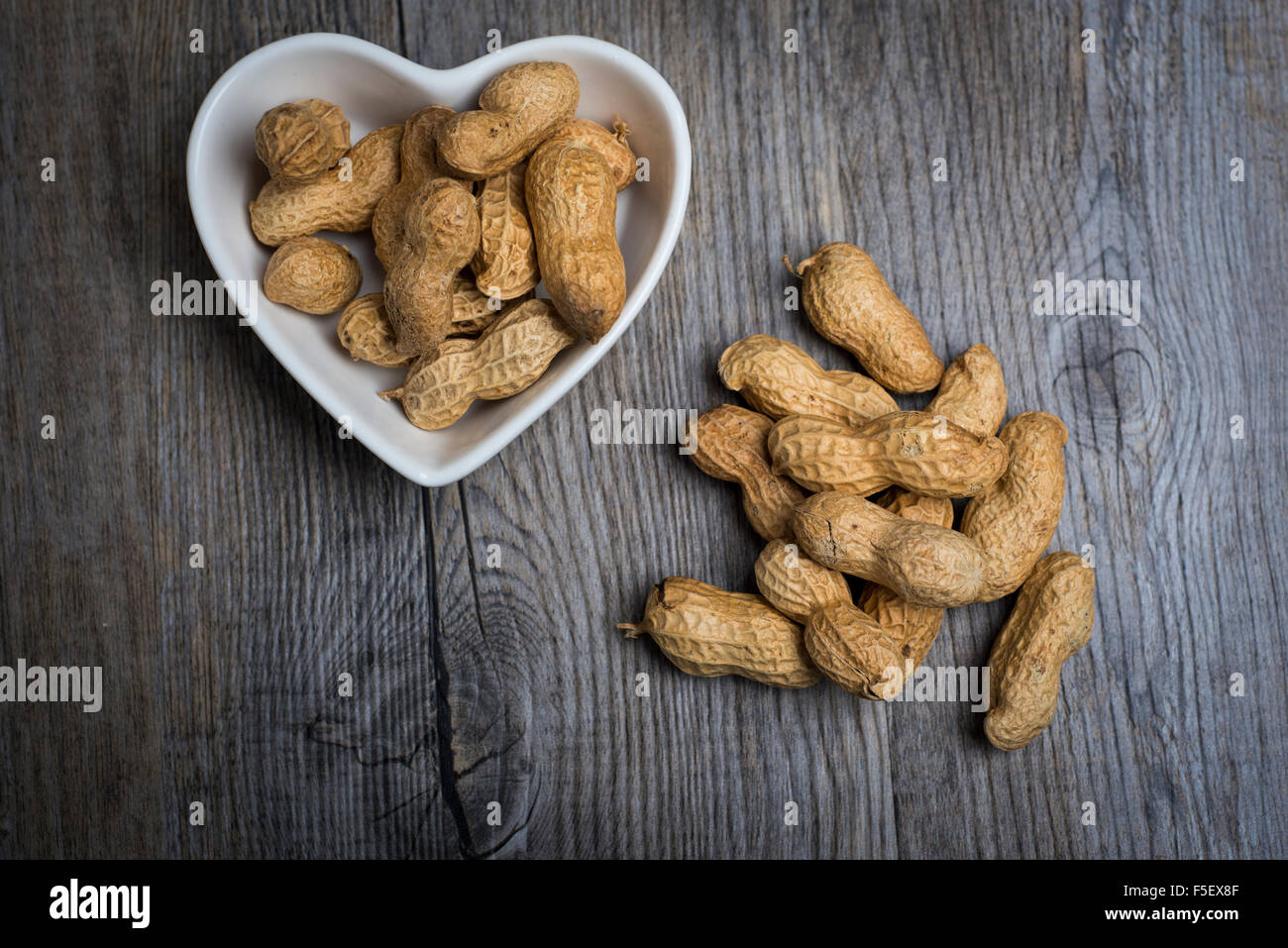 Monkey noix dans un bol en forme de coeur Banque D'Images