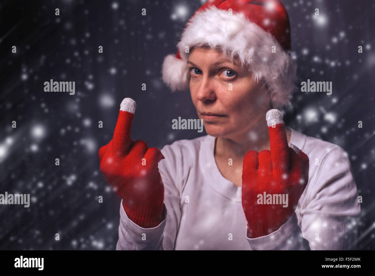 Belle femme en costume père noël donner doigt moyen, selective focus. Banque D'Images