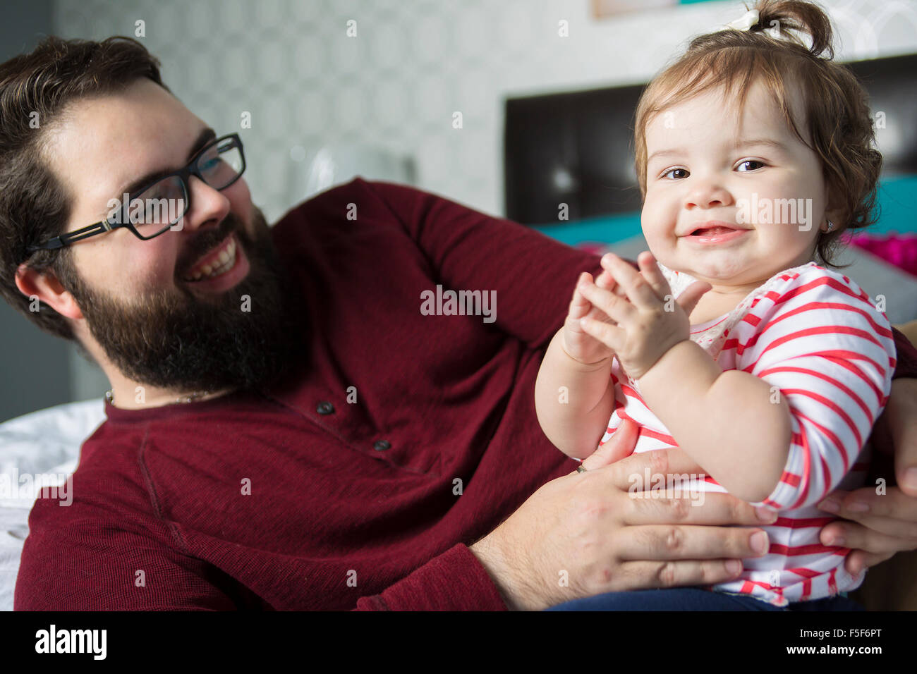 Portrait d'un jeune père avec un bébé dans le lit à la maison Banque D'Images