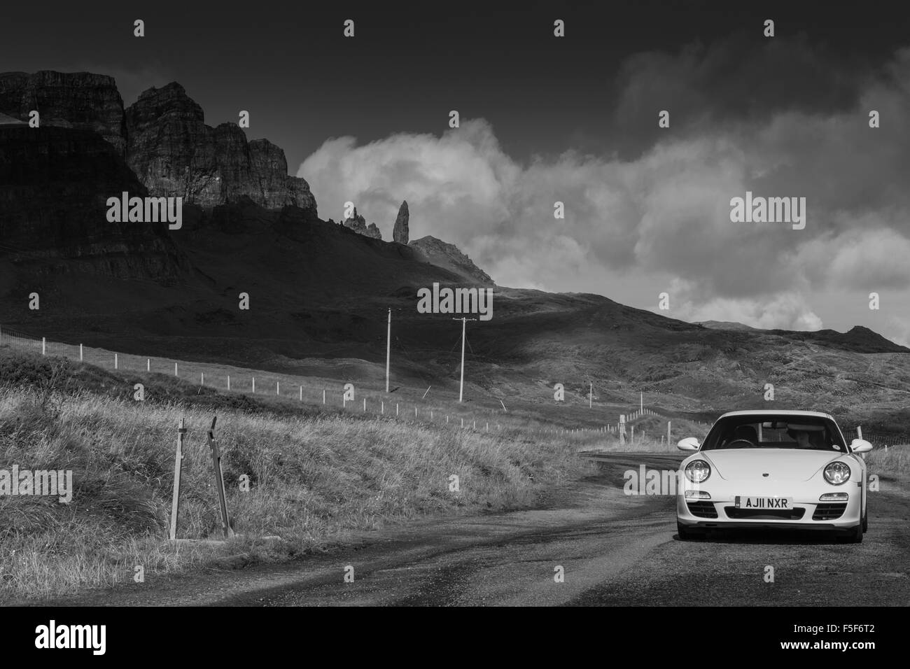 Une Porsche 911 sur le côté de la route avec le vieil homme de Storr, île de Skye en arrière-plan. Banque D'Images