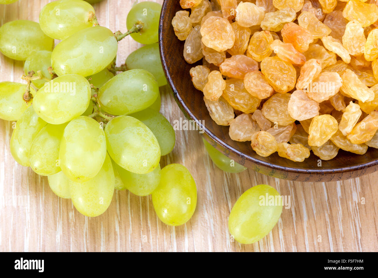Raisins sans pépins blancs et les raisins secs sultanines dans un bol en bois Banque D'Images