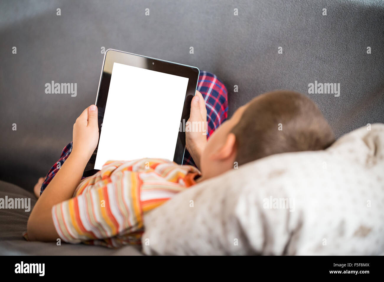 Little Boy using a digital tablet in bed Banque D'Images