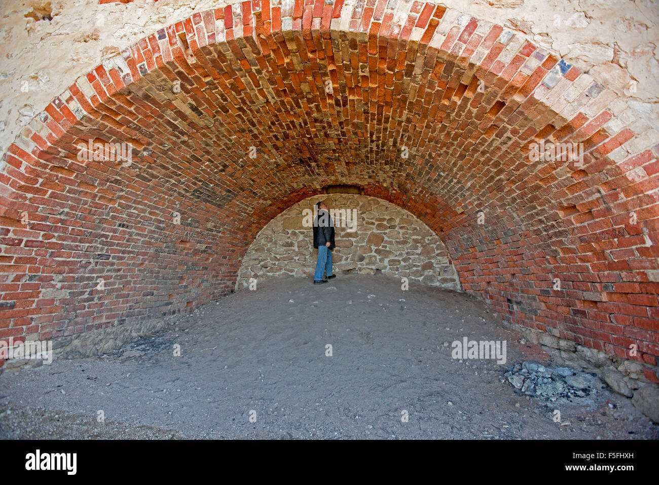 L'homme à l'intérieur de l'immense four à chaux historique avec plafond voûté en brique rouge et des murs à Wool Bay, la péninsule de Yorke SA Banque D'Images