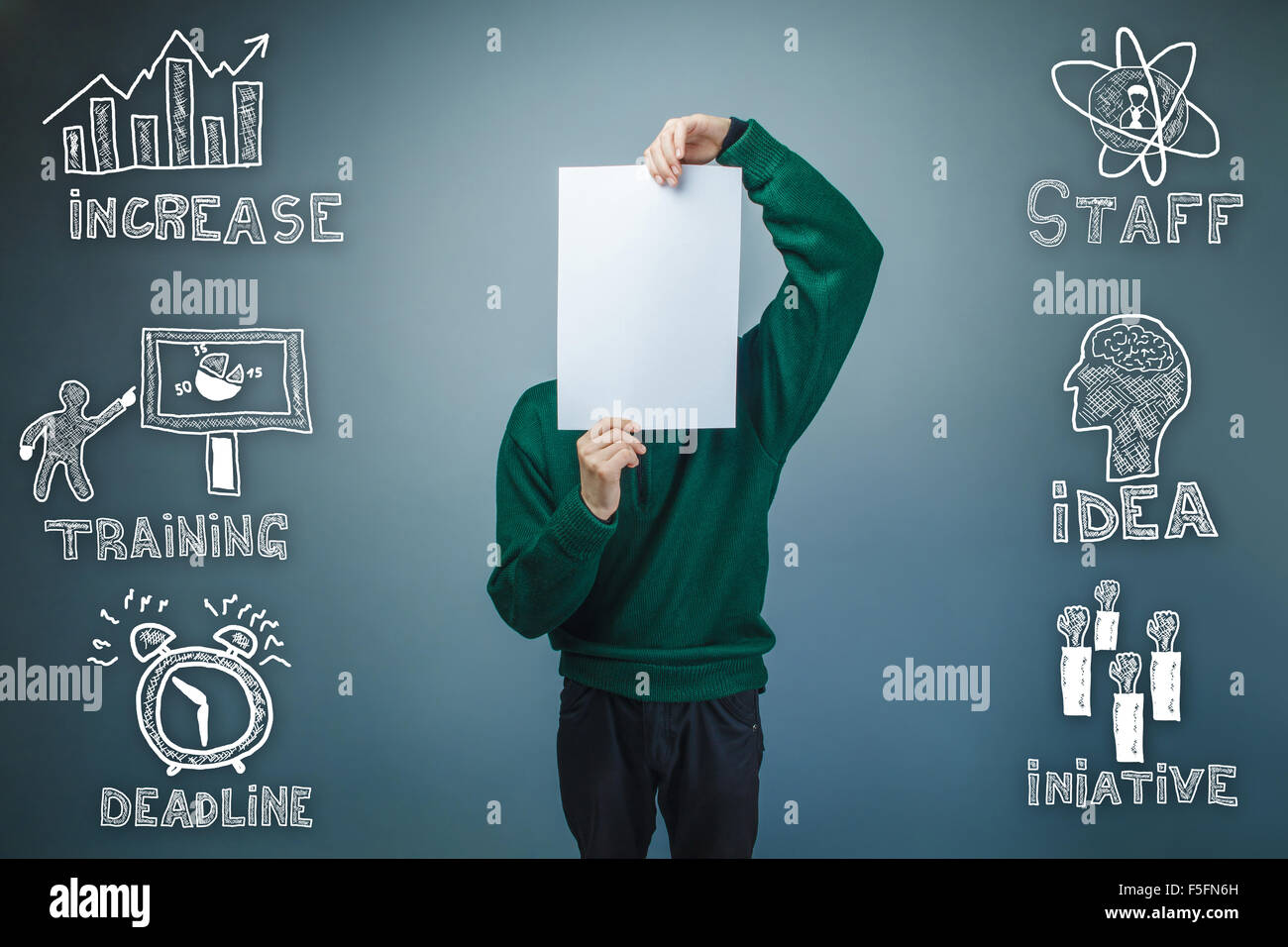 Garçon en chandail vert tenant une feuille vierge de papier croquis à main Banque D'Images