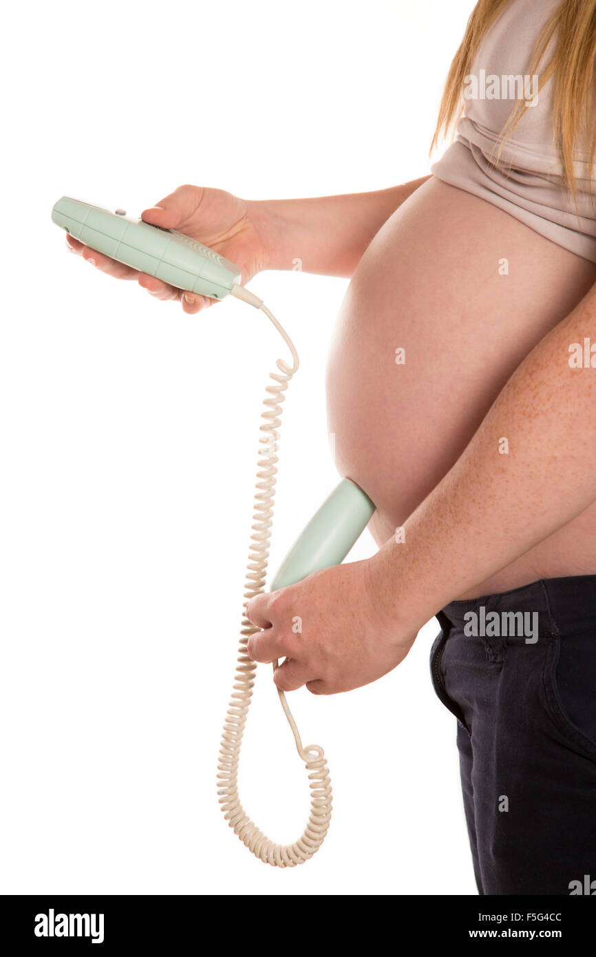 Les femmes à l'aide d'un doppler accueil sur sa découpe pregnant belly Banque D'Images