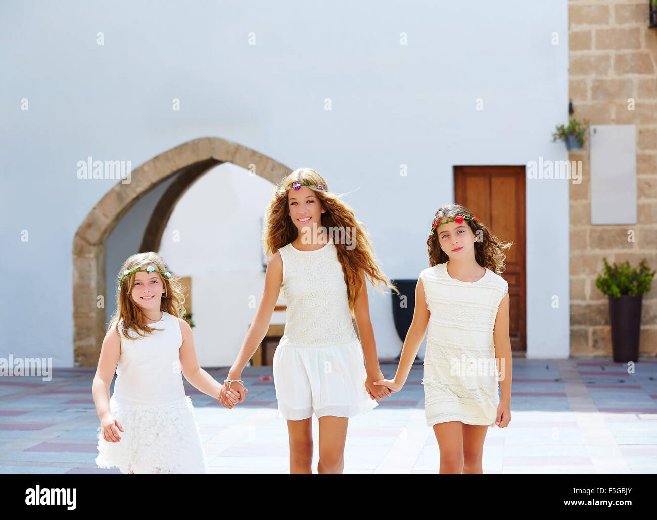 Kid filles marche main dans la main au village méditerranéen blanc d'Espagne Banque D'Images