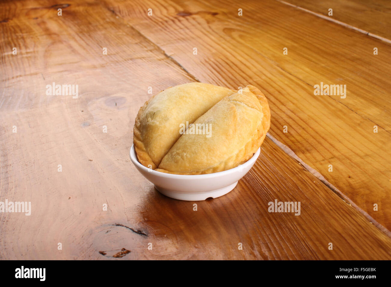 Malaisie délicieux curry puff servi sur plaque blanche sur fond de bois Banque D'Images