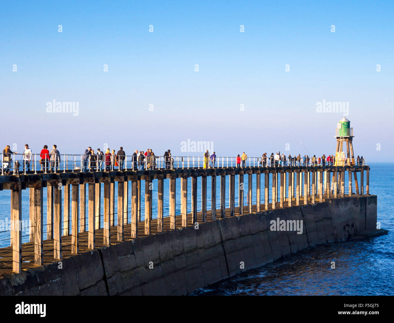 Whitby West Pier de monde bwith extension aux personnes bénéficiant du soleil sur le Whitby Goth semaine Novembre 2015 Banque D'Images