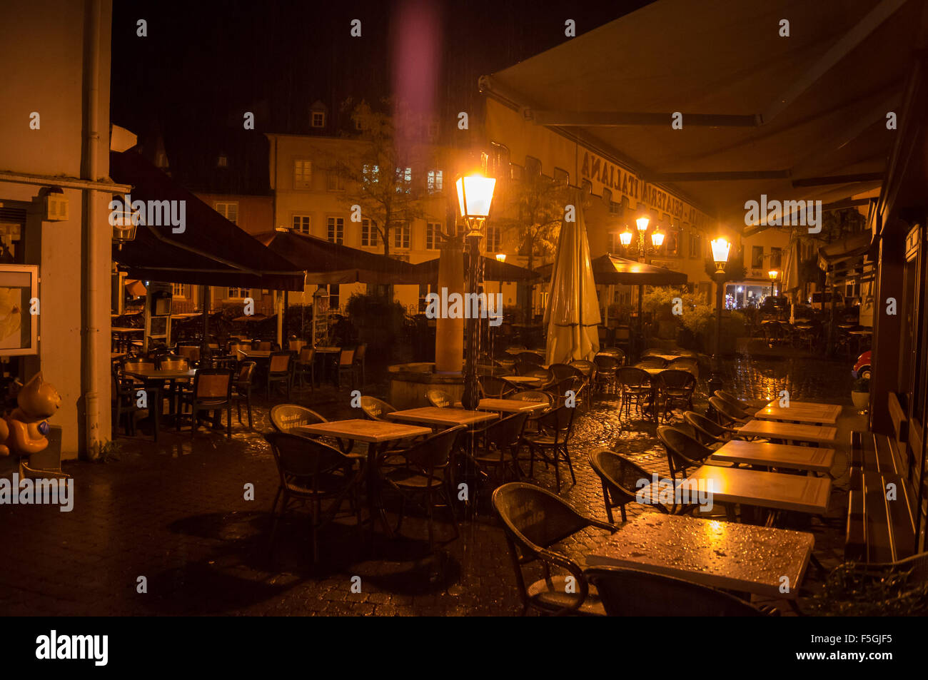 Tables de restaurant de nuit sous la pluie, Saarburg, Rheinland-Pfalz, Allemagne Banque D'Images