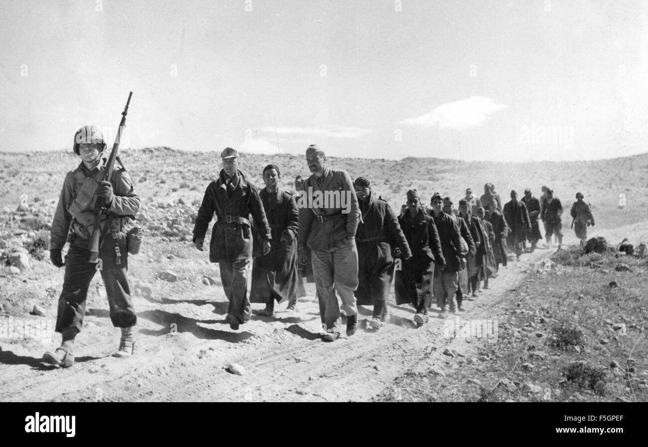 Campagne d'AFRIQUE DU NORD DANS LA SECONDE GUERRE MONDIALE. Un soldat américain avec un groupe de prisonniers italiens vers la fin de la campagne en mai 1943 Banque D'Images Campagne d'AFRIQUE DU NORD DANS LA SECONDE GUERRE MONDIALE. Un soldat américain avec un groupe de prisonniers italiens vers la fin de la campagne en mai 1943 Banque D'Images
