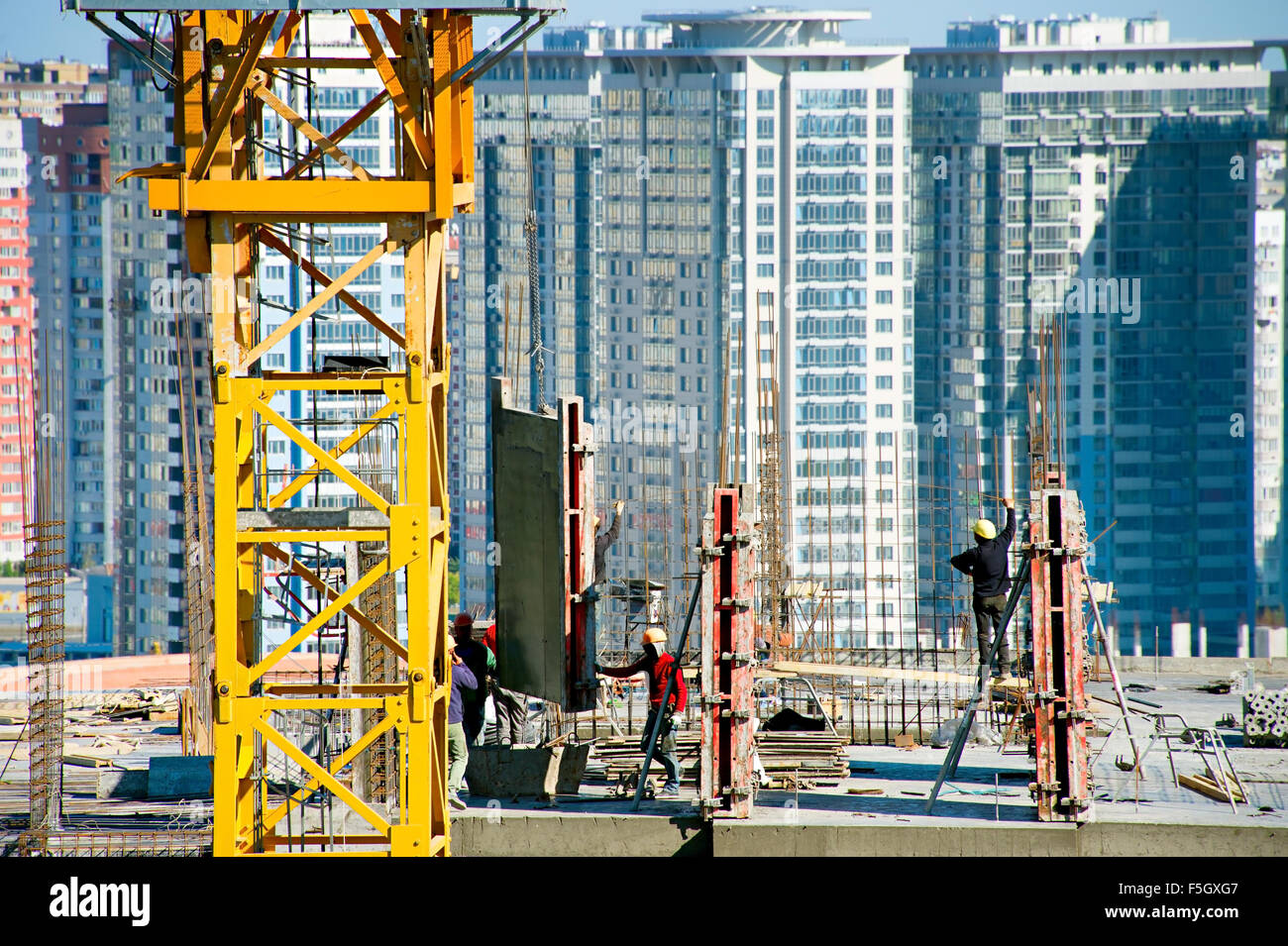 Groupe de travailleurs au chantier de construction sur un sommet d'un bâtiment Banque D'Images