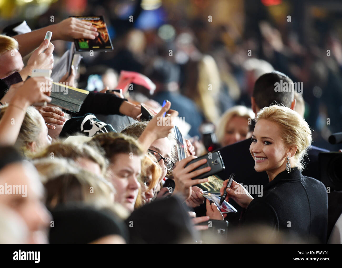Berlin, Allemagne. 4ème Nov, 2015. L'actrice Jennifer Lawrence arrive et offre aux fans des autographes dans le monde de la premeiere Hunger Games : Clarak Partie 2 au Cinestar cinéma de Berlin, Allemagne, 4 novembre 2015. Photo : JENS KALAENE/DPA/Alamy Live News Banque D'Images