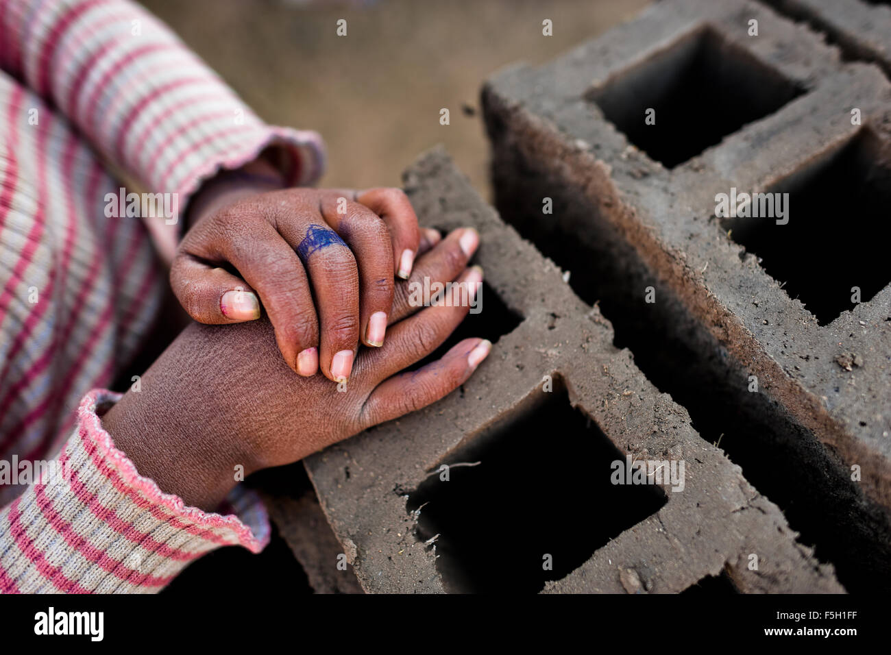 Un anneau créé par un stylo à bille est vu sur un doigt d'une jeune fille travaillant dans une briqueterie dans la périphérie de Puno, Pérou. Banque D'Images