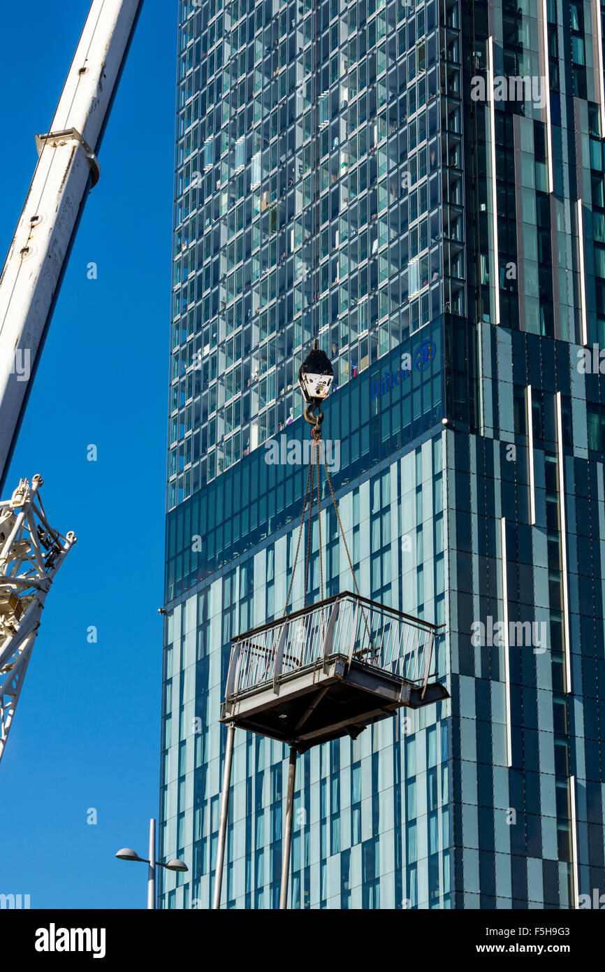 L'article de démantelé étapes être soulevé par une grue avec la Beetham Tower derrière. Manchester, Angleterre, RU Banque D'Images