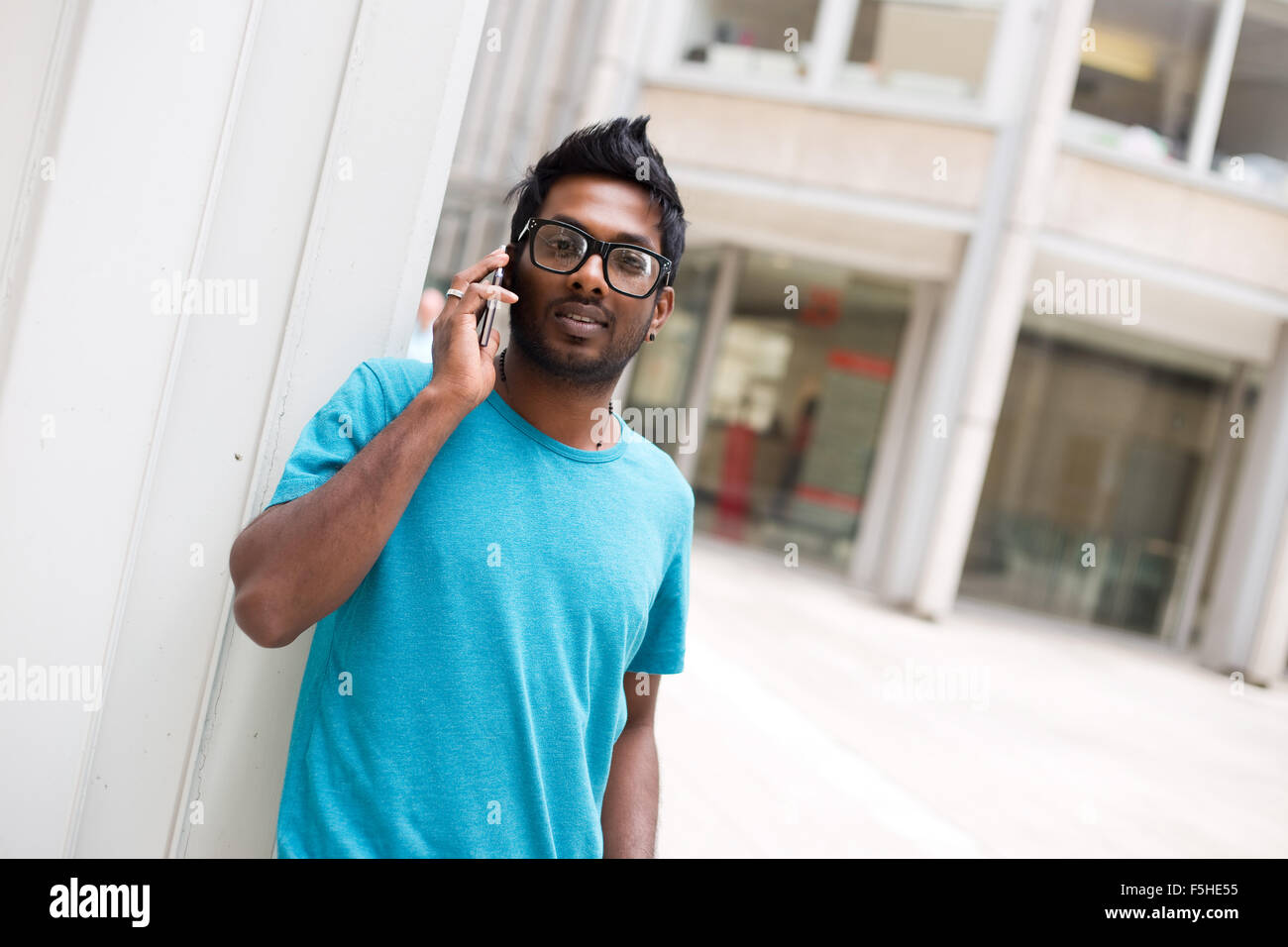 Jeune homme parle sur son téléphone mobile Banque D'Images