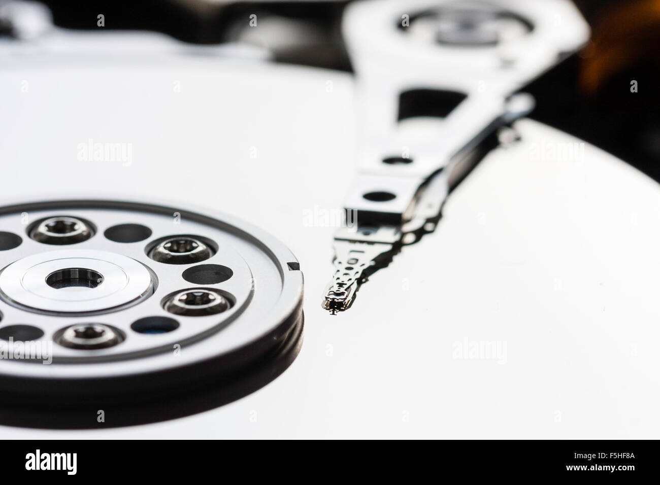 Intérieur du disque dur de l'ordinateur. Le bras actionneur avec têtes de lecture et d'écriture sur le plateau et le disque. Macro close up. Banque D'Images