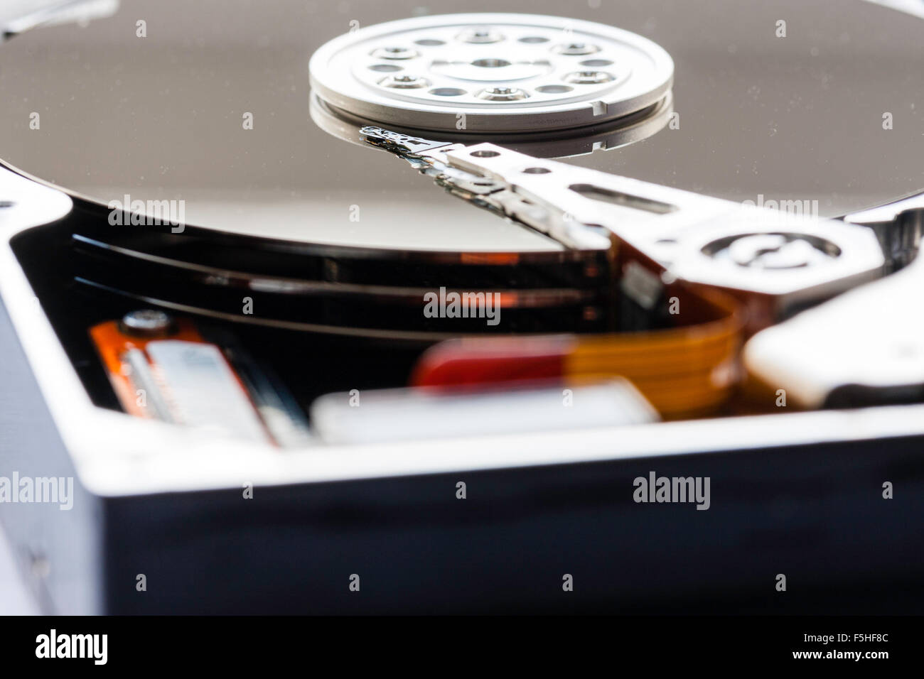 Intérieur du disque dur de l'ordinateur. Le bras actionneur avec têtes de lecture et d'écriture sur le plateau et le disque. Macro close up. Banque D'Images