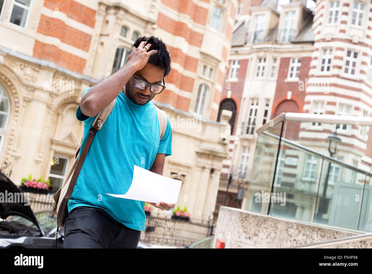 Jeune homme inquiet la lecture d'une lettre dans la rue Banque D'Images