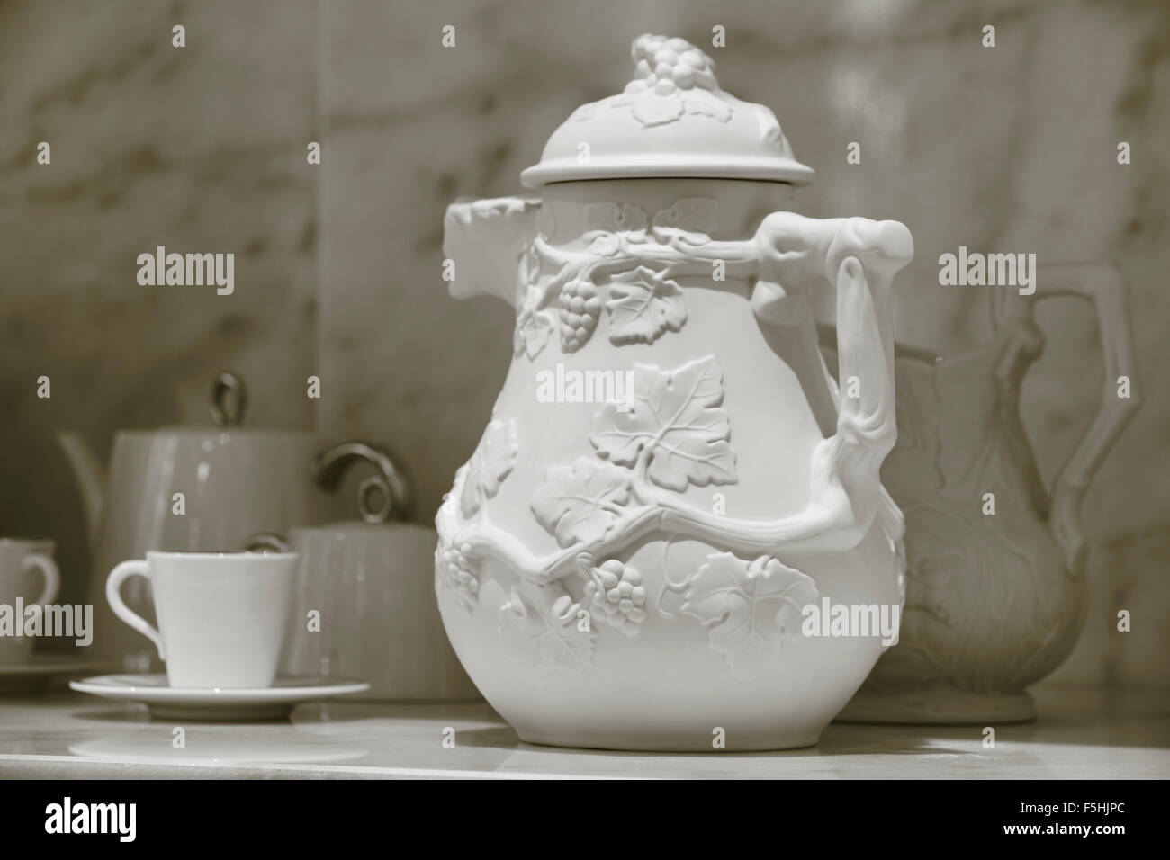 Verseuse en céramique et vaisselle en arrière-plan modèle floral Banque D'Images