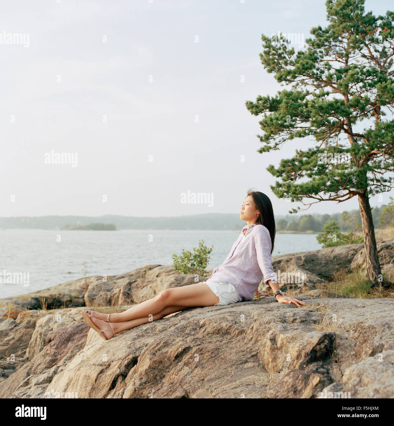 La Suède, l'archipel de Stockholm, Sodermanland, Nacka, Mid-adult woman relaxing on beach Banque D'Images