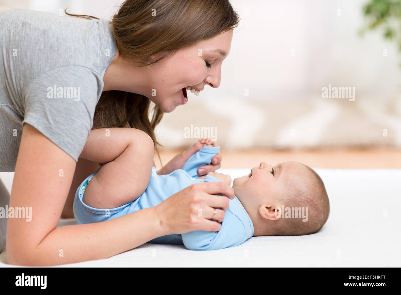 Heureuse mère jouant avec sa fille adorable bébé Banque D'Images