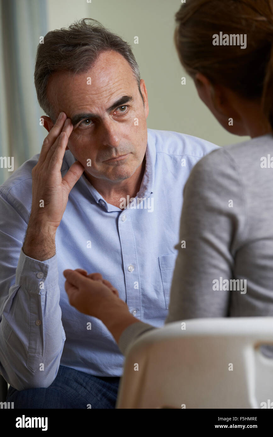 Homme Mature déprimé parlant à conseiller Banque D'Images