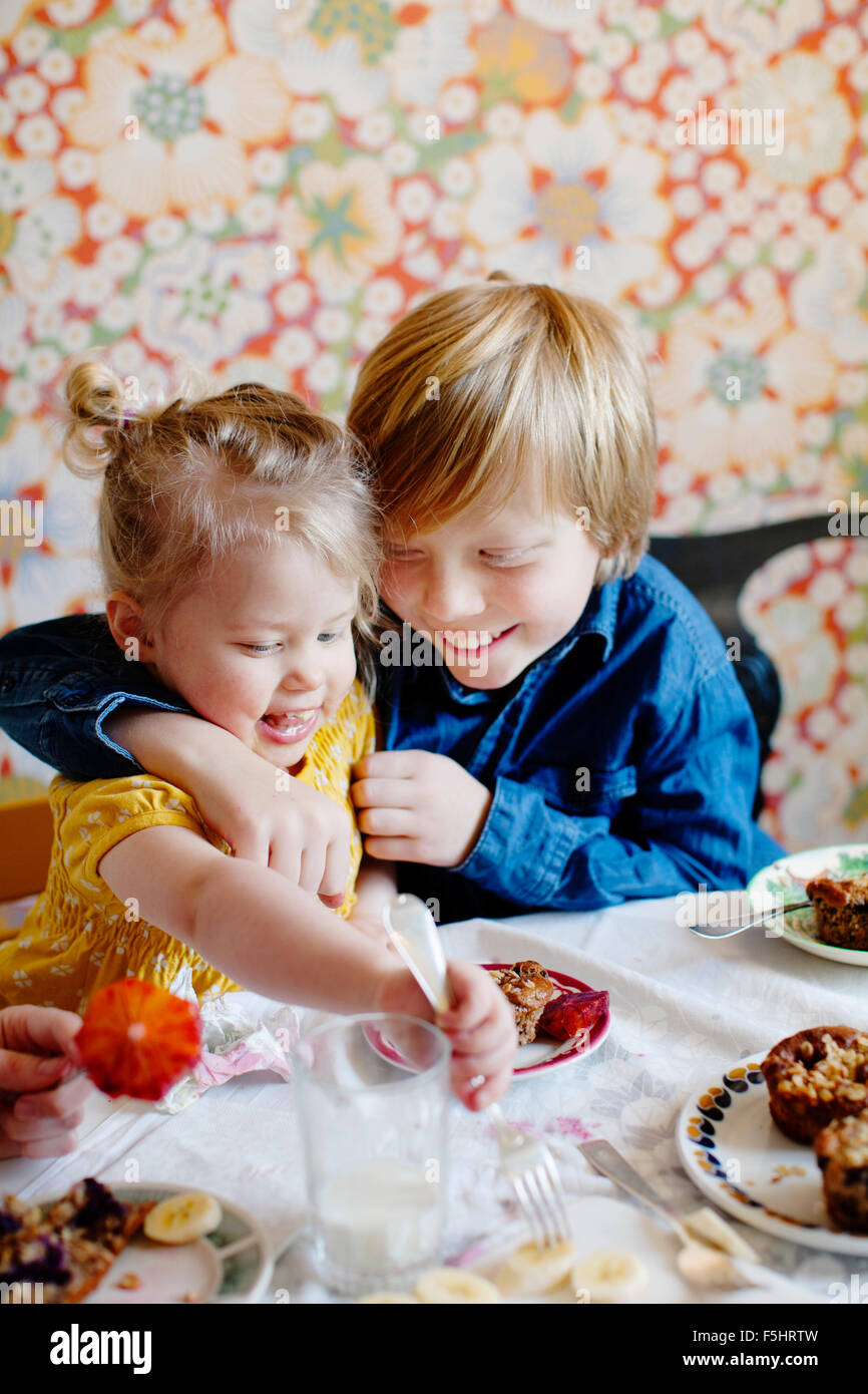 La Suède, Boy (10-11) and girl (2-3) eating cake Banque D'Images