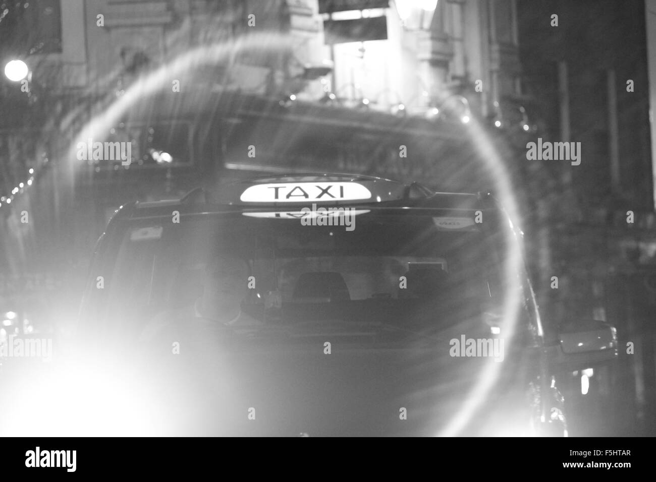 Taxi noir avec anneau lumineux flare, London, UK Banque D'Images