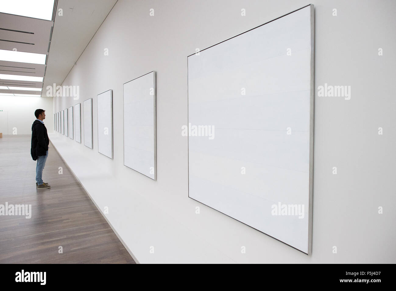 Düsseldorf, Allemagne. 05Th Nov, 2015. Un visiteur regarde la série "Les îles I-XII" à partir de 1979 par Agnes Martin dans la Kunstsammlung Nordrhein-Westfalen à Duesseldorf, Allemagne, 05 novembre 2015. La rétrospective 'Agnes Martin' - avec 130 peintures, dessins et gravures - peut être vu dans la Kunstsammlung Nordrhein-Westfalen de 07 novembre 2015 jusqu'à 06 mars 2016. Photo : FEDERICO GAMBARINI/dpa/Alamy Live News Banque D'Images