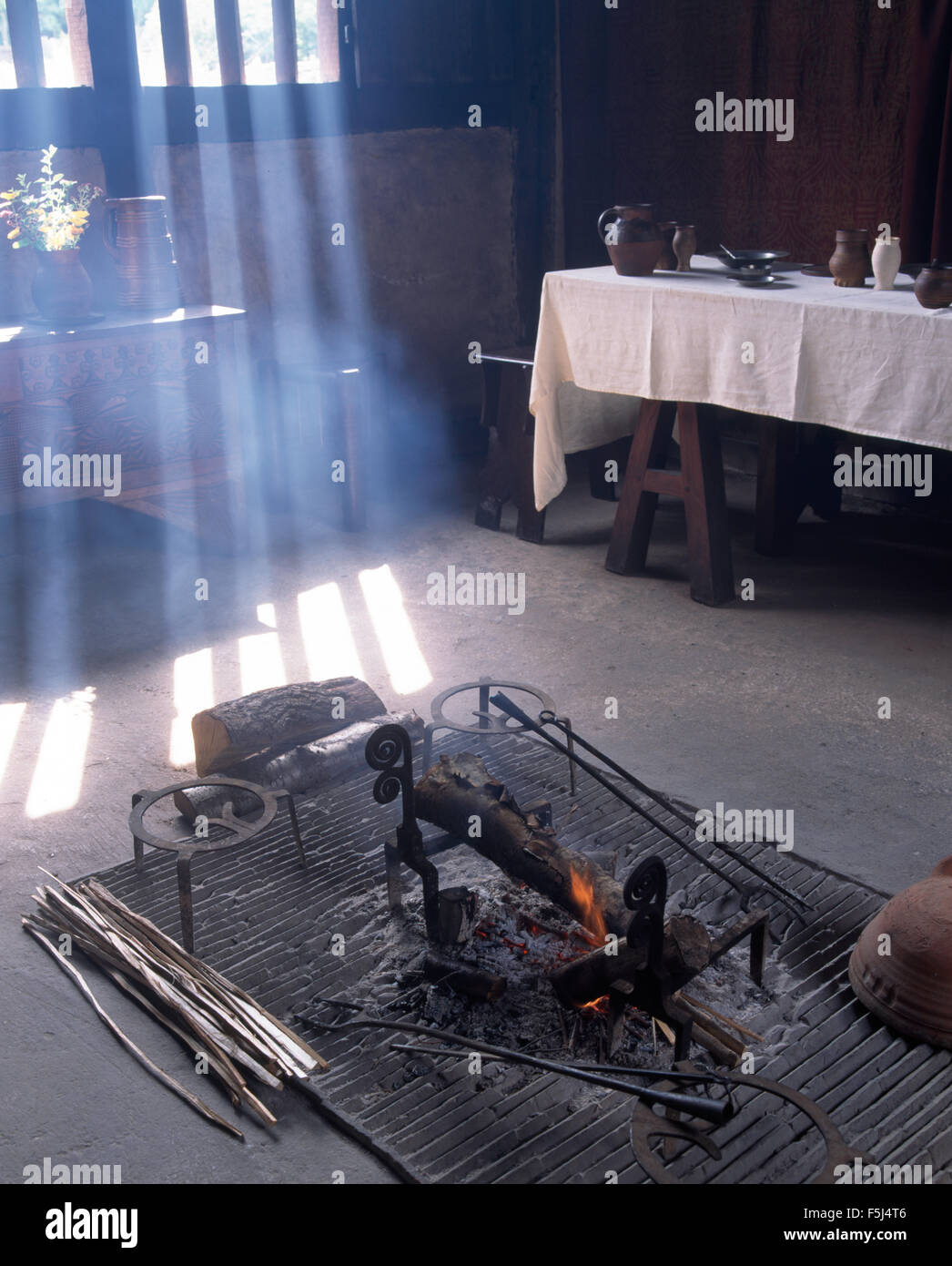 Le feu allumé sur la grille de métal dans la salle à manger au Weald et Downland Museum à West Sussex Banque D'Images