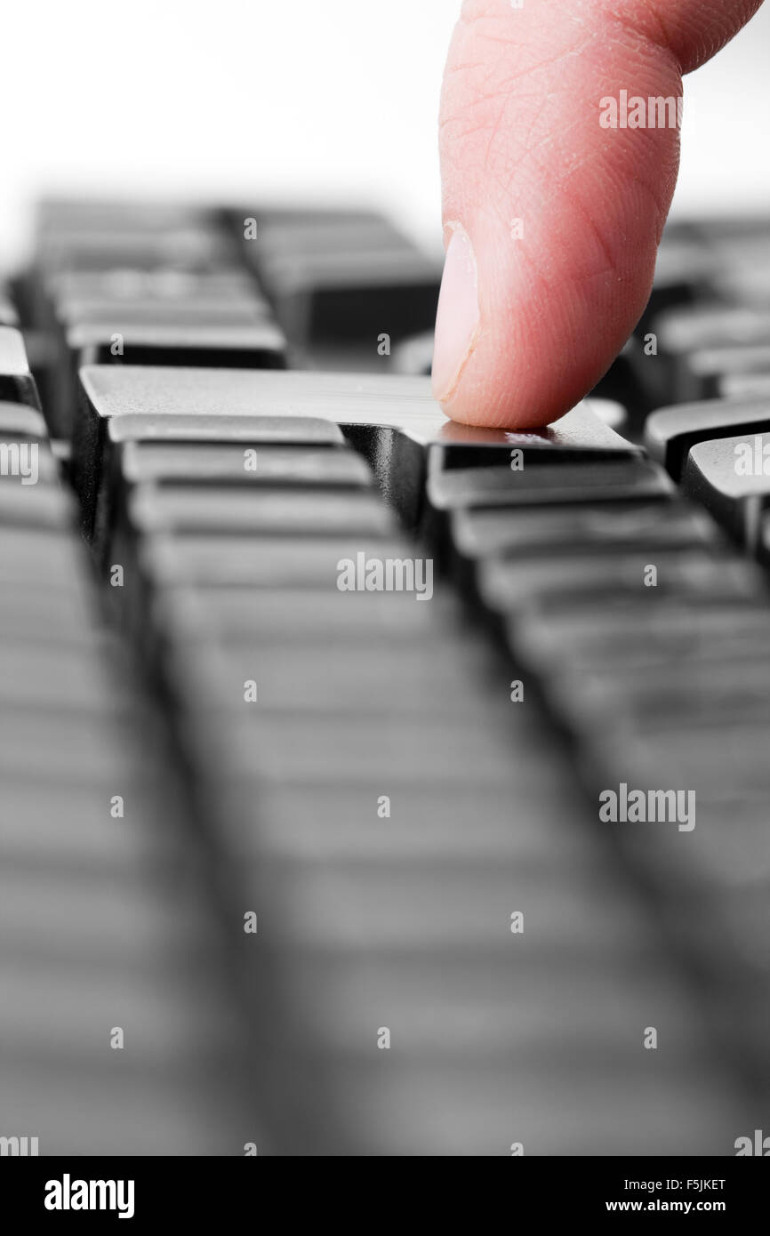 Vue rapprochée d'un doigt appuyé sur la touche 'Entrée' Banque D'Images