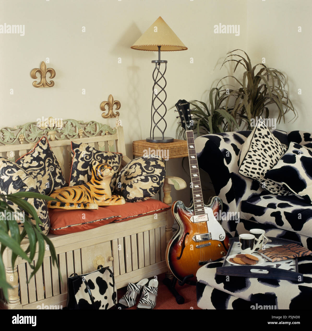 Noir +blanc animal canapé et coussins dans un salon des années 90 Banque D'Images