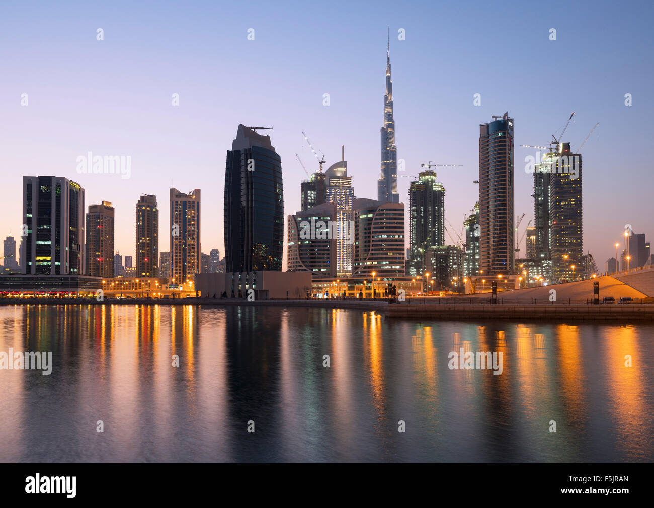 Skyline de tours reflété dans le ruisseau au crépuscule dans la baie d'affaires à Dubaï Émirats Arabes Unis Banque D'Images