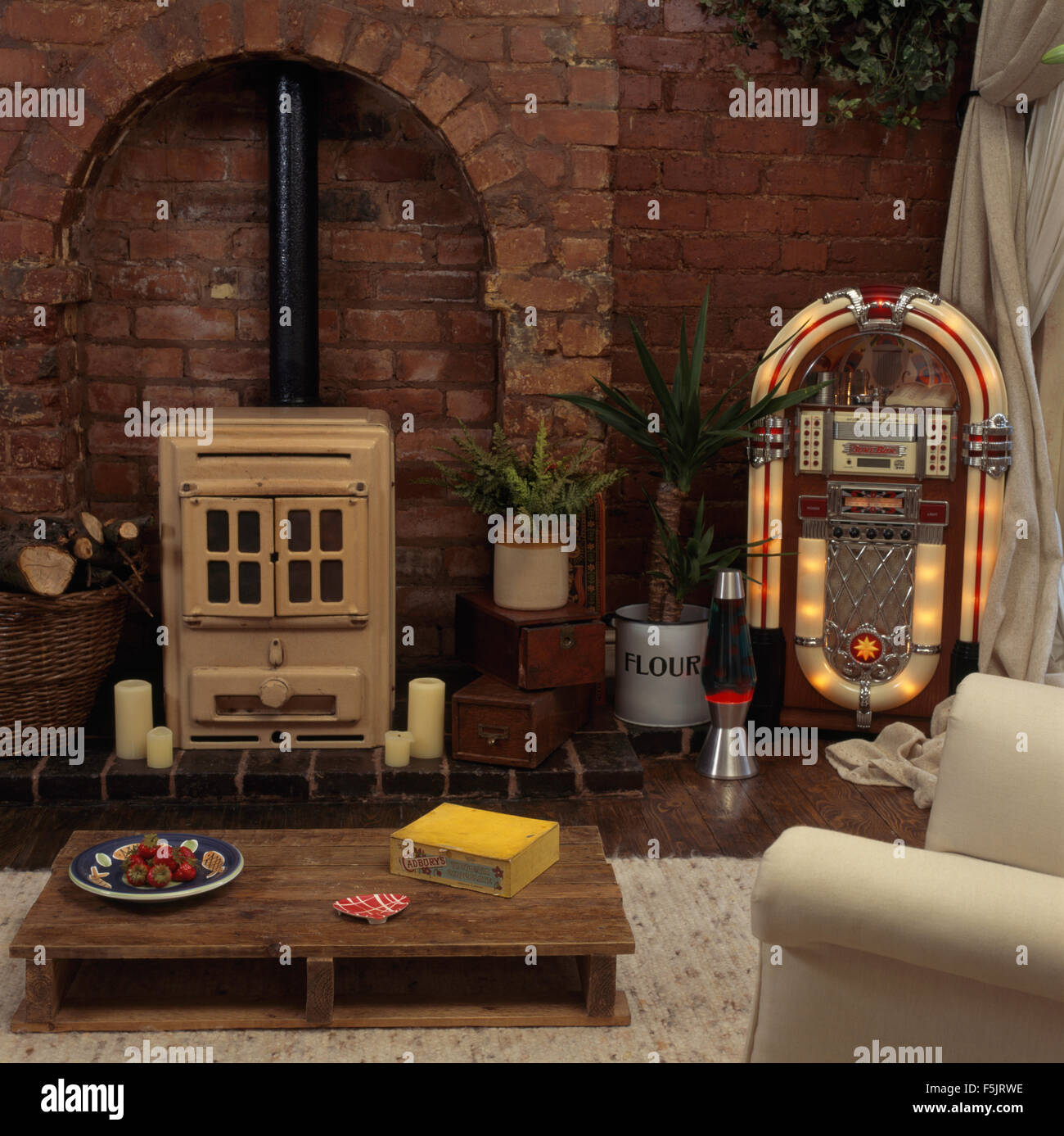 Vintage cream cuisinière et d'un jukebox dans un salon avec une vieille palette utilisé comme une table de café Banque D'Images