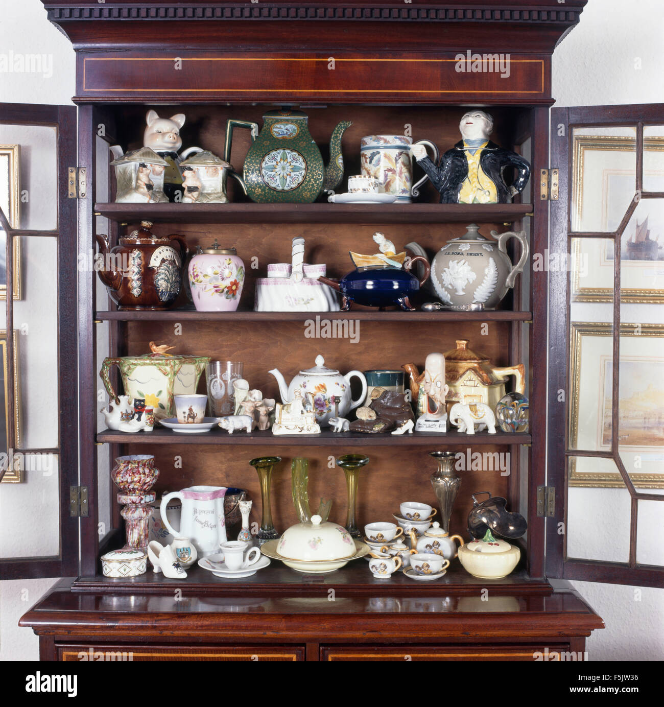 Collection de meubles anciens de la Chine sur des étagères dans un vaisselier avant en verre vintage Banque D'Images