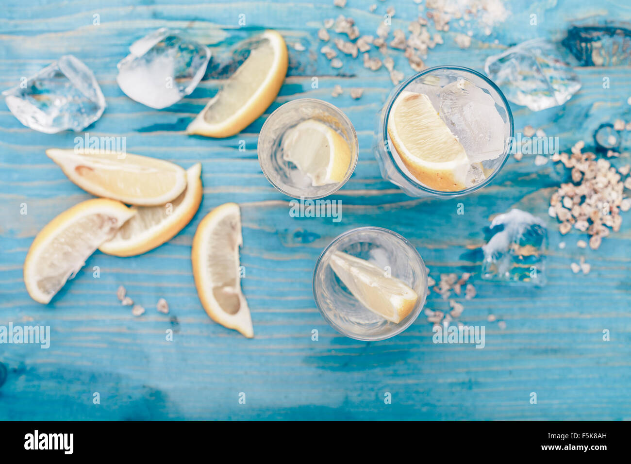 Ingrédients pour la limonade. Citrons tranchés, rugueux de la glace concassée et le sucre de canne sur la table en bois bleu. Selective focus Banque D'Images