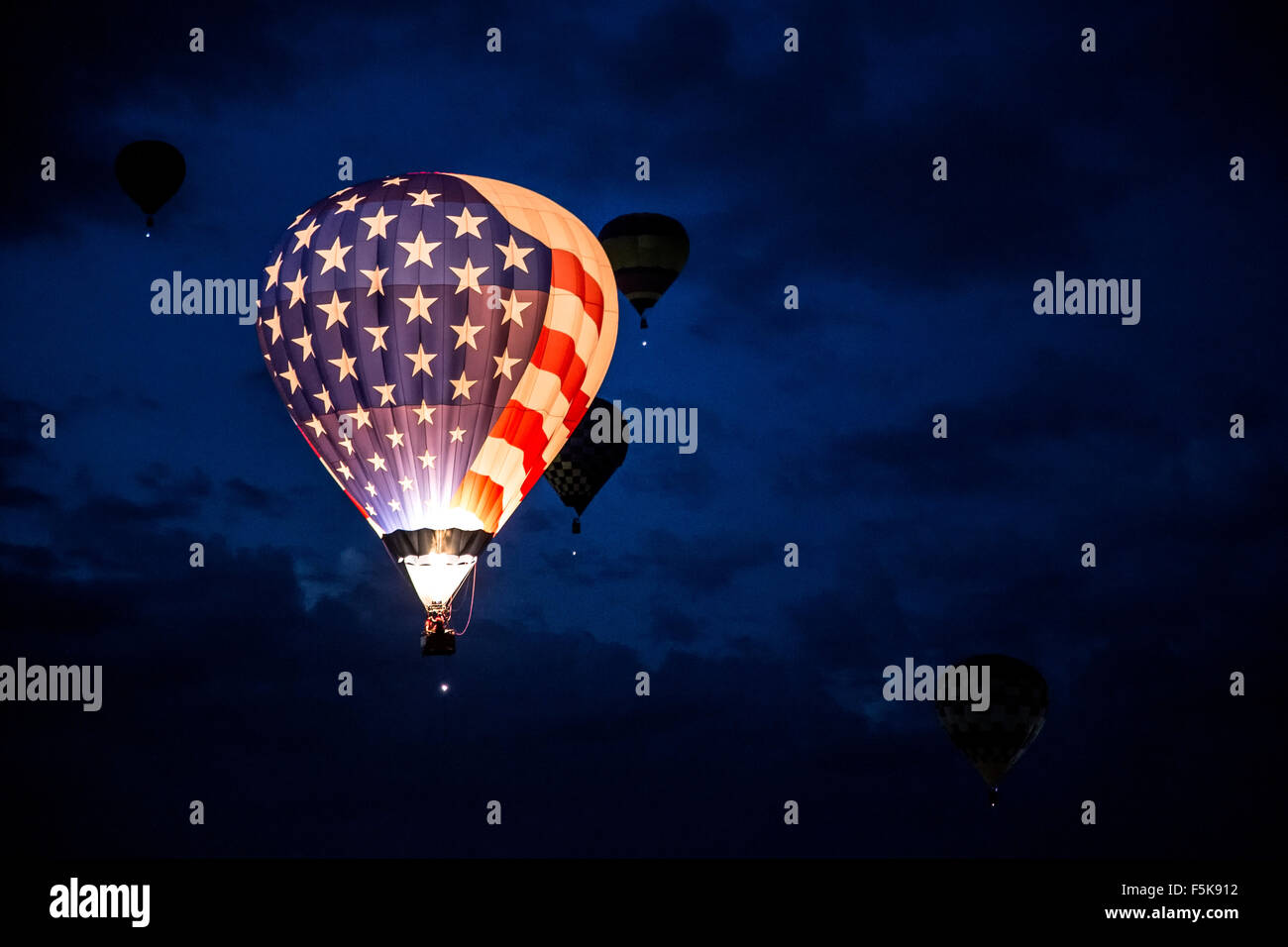 Allumé Stars and Stripes hot air balloon flying Dawn Patrol, Albuquerque International Balloon Fiesta, Nouveau Mexique USA Banque D'Images