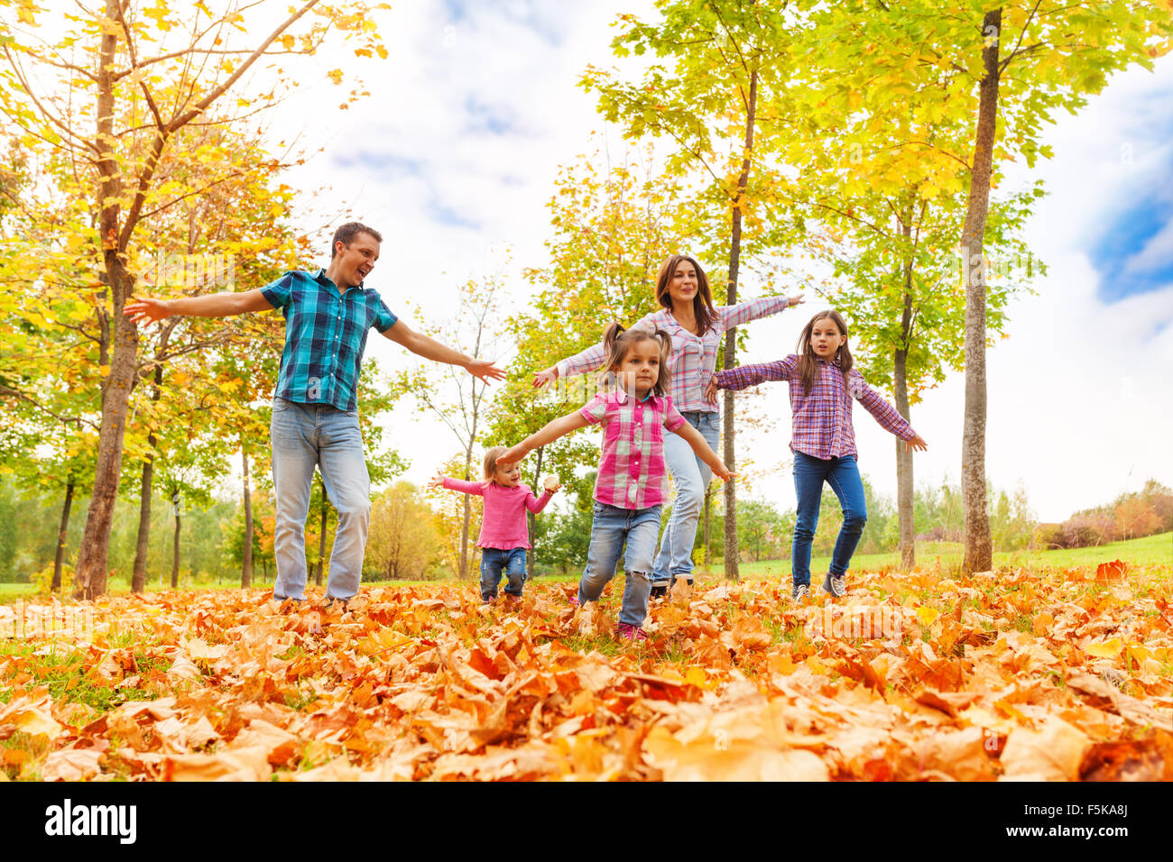 Famille avec de nombreux enfants courir dans le parc en automne Banque D'Images