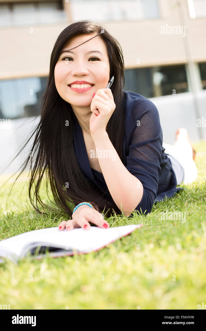 Étudiant japonais allongés sur l'herbe Banque D'Images