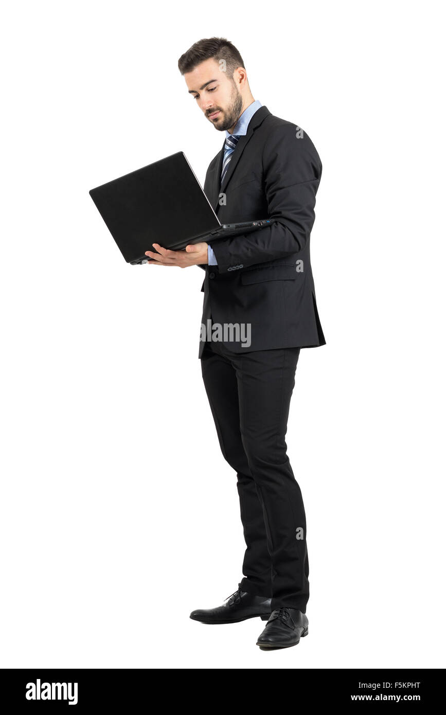 Jeune homme d'affaires permanent travaillant sur un ordinateur portable. La pleine longueur du corps portrait studio isolated over white background Banque D'Images