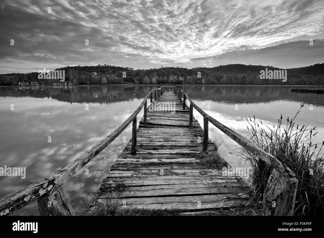 Ancienne jetée en bois au lever du soleil en B&W Banque D'Images