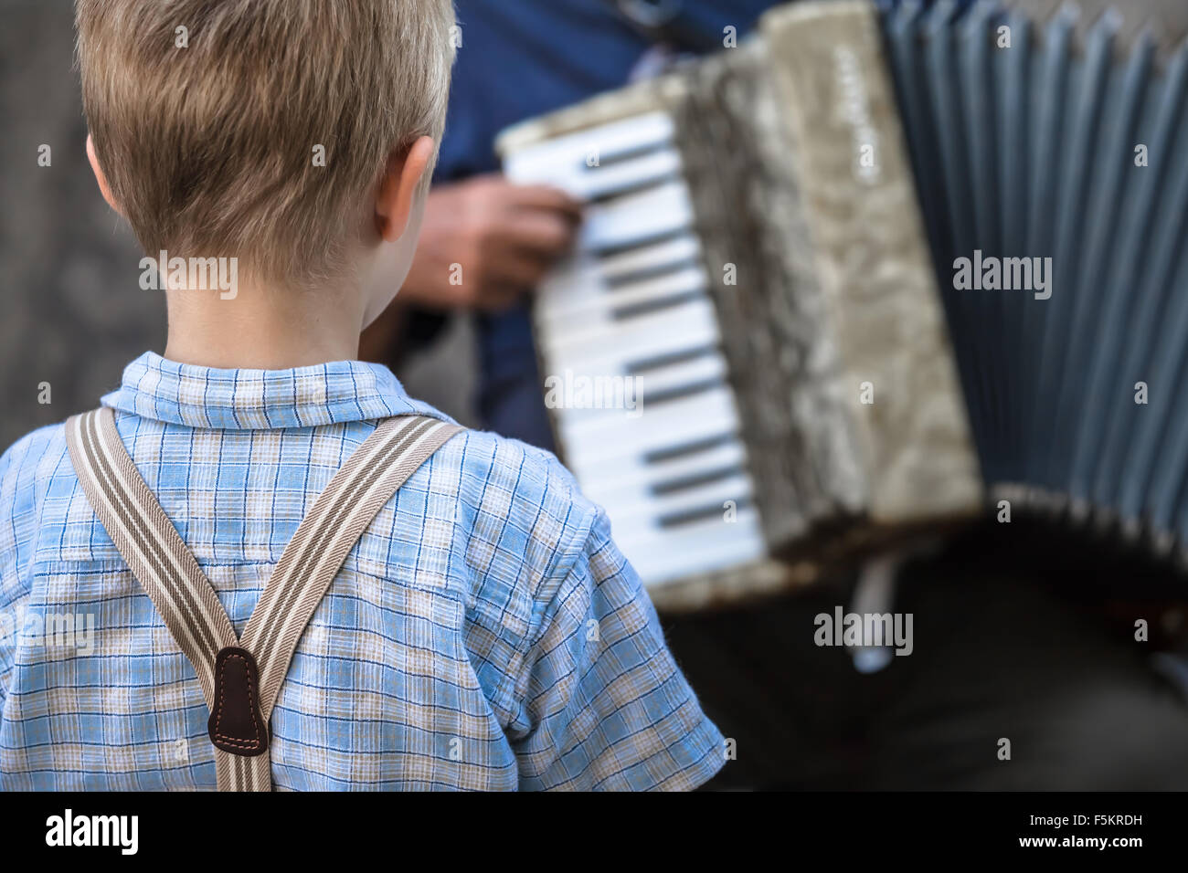 Petit garçon style vintage avec bretelles écouter attentivement un musicien  de rue jouant un accordéon / Concert de musique de la petite enfance Photo  Stock - Alamy